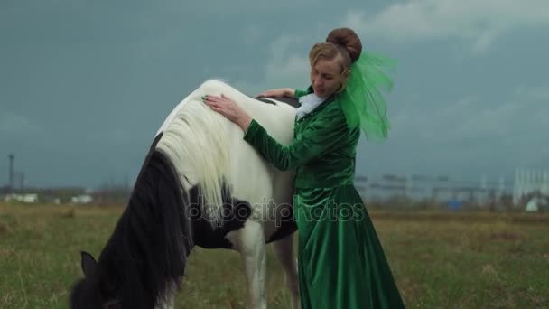 Una donna in abito verde sta cavalcando un cavallo 4k — Video Stock