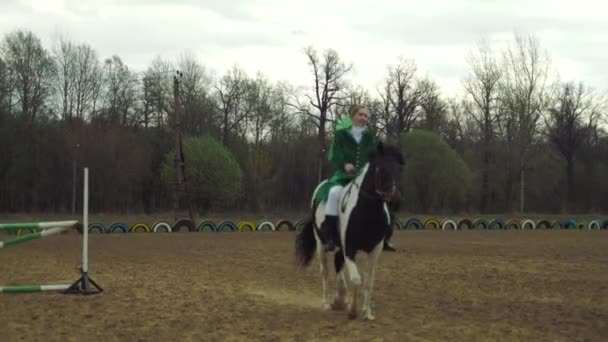 Una mujer con traje verde monta un caballo 4k — Vídeo de stock