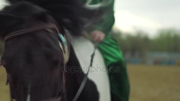 Женщина в зеленом костюме едет верхом на лошади 4К — стоковое видео