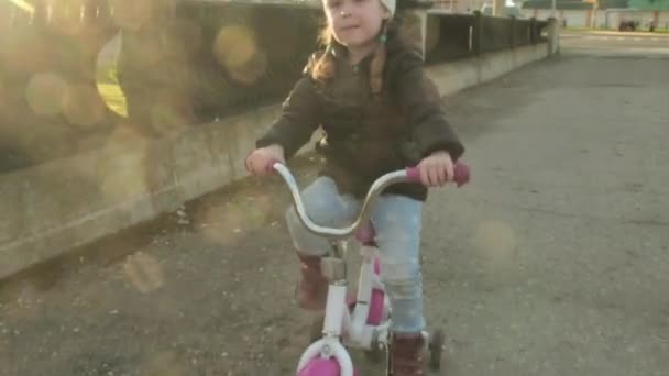 Criança feliz andando de bicicleta ao ar livre. Miúdo bonito no capacete de segurança andar de bicicleta ao ar livre. Menina em uma bicicleta vermelha Atividade pré-escolar saudável do verão das crianças. Movimento lento . — Vídeo de Stock