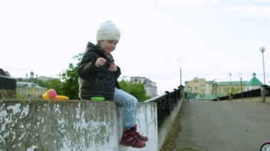 Anne ve kızı bahçede sabun köpüğü üfleme