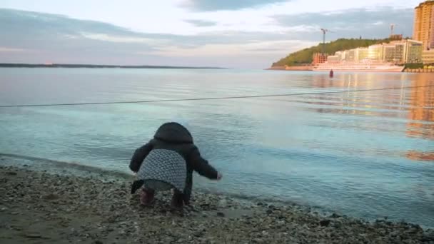 Dotter och mor kastar sten på havet — Stockvideo