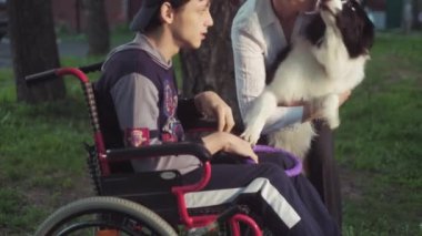 Adam tekerlekli sandalyede bir köpek, canitis tedavisi, sakatlık tedavi ile bir köpek eğitim yoluyla özürlü kişi oynuyor