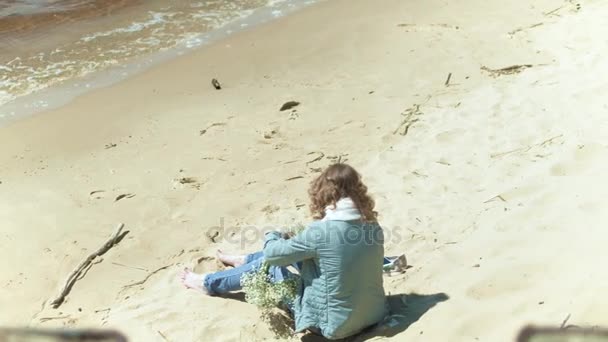 Kobieta, pobyt na plaży z kwiatem w słoneczny dzień 4k — Wideo stockowe