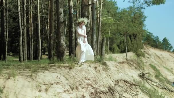 Kobieta w białej sukni, pobyt na plaży z kwiatem w słoneczny dzień 4k — Wideo stockowe