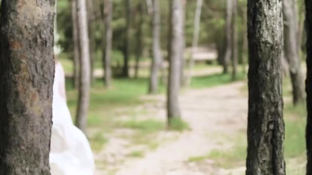 Красива жінка в білій сукні в лісі з квітами 4k — стокове відео