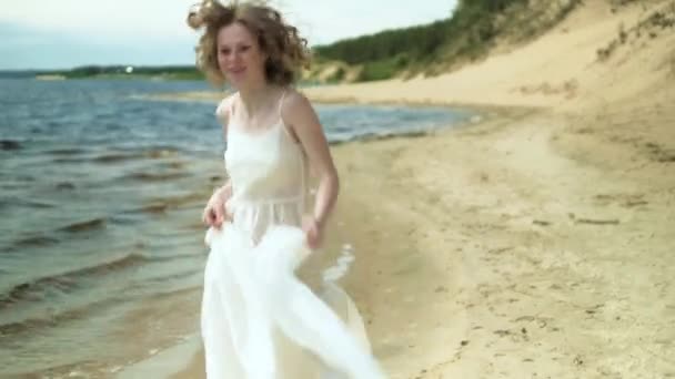 Donna In abito bianco soggiorno su una spiaggia con fiore alla giornata di sole 4k — Video Stock