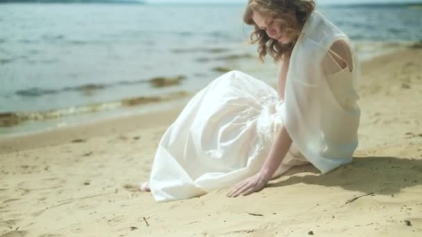 Donna In abito bianco soggiorno su una spiaggia con fiore alla giornata di sole 4k — Video Stock