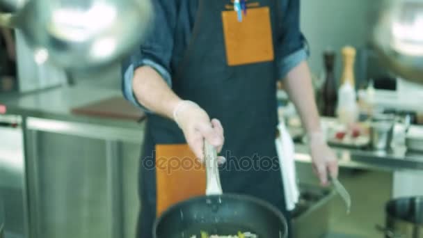 Kocken i restaurangen tillagar rätter i köket. 4k — Stockvideo