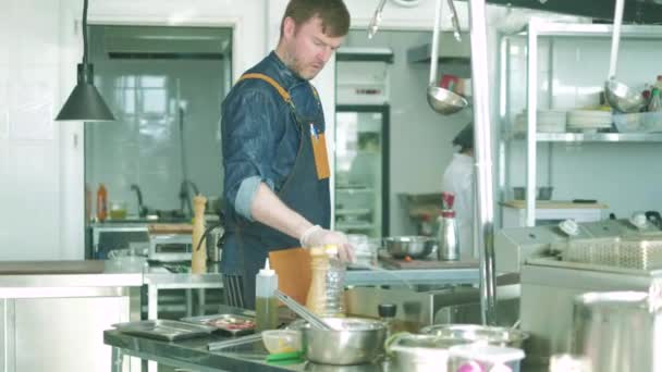 Chef-kok van het restaurant bereidt gerechten in de keuken. 4k — Stockvideo