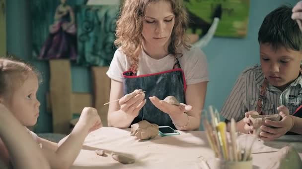 Argila oleiro mãos roda cerâmica trabalho oficina professor e menina aluno 4k — Vídeo de Stock