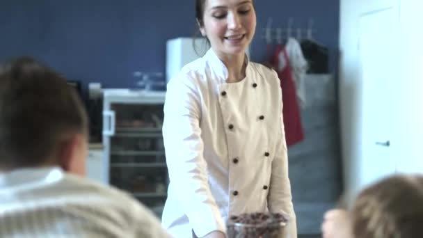 Закрыть портрет молодой пекарь рассматривает и трогает пальцем шоколад 4k — стоковое видео