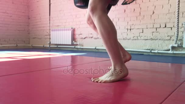 Mooie kickboksen vrouw opleiding bokszak in felle kracht van fitness studio fit lichaam kickbokser serie 4k — Stockvideo