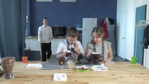 Close-up portret jonge baker onderzoekt en aanraken met behulp van vinger chocolade 4k — Stockvideo