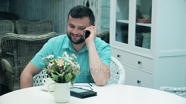 Um homem jovem e ambicioso falando no telefone 4k — Vídeo de Stock