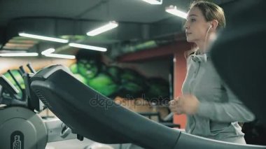 Çekici kız 4 k spor salonunda bir koşu bandı üzerinde çalışan