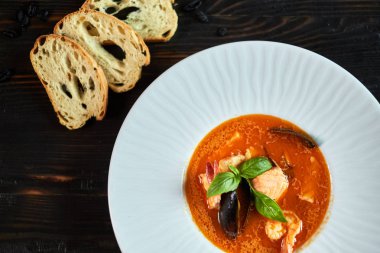 Domates sosu ve Hindistan cevizi sütü eski bir ahşap tepsi ile ev yapımı deniz mahsulleri çorbası