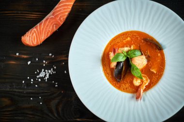 Domates sosu ve Hindistan cevizi sütü eski bir ahşap tepsi ile ev yapımı deniz mahsulleri çorbası