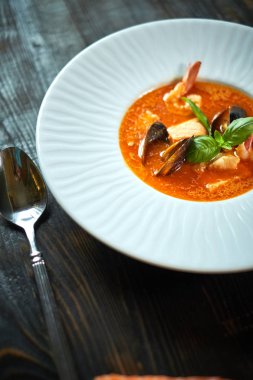 Domates sosu ve Hindistan cevizi sütü eski bir ahşap tepsi ile ev yapımı deniz mahsulleri çorbası