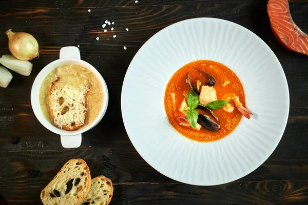 Domates sosu ve Hindistan cevizi sütü eski bir ahşap tepsi ile ev yapımı deniz mahsulleri çorbası