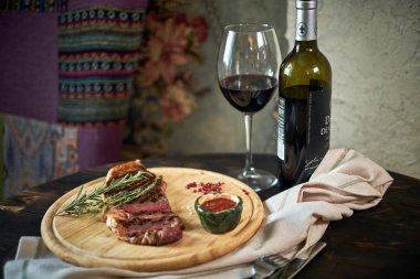 Biberiye ve baharatlar ile rustik kesme tahtası üzerinde orta az pişmiş ızgara biftek dilimlenmiş, karanlık rustik metal arka plan üstten görünüm, yerleştirmek için metin jpg