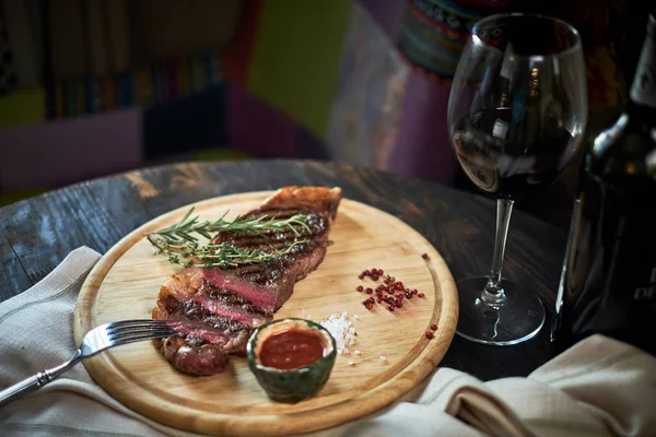 Biberiye ve baharatlar ile rustik kesme tahtası üzerinde orta az pişmiş ızgara biftek dilimlenmiş, karanlık rustik metal arka plan üstten görünüm, yerleştirmek için metin jpg