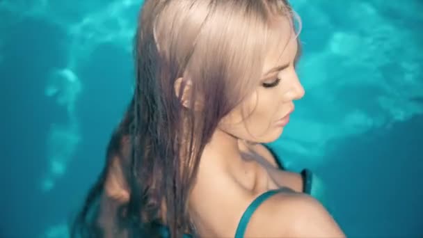 Молодая красивая женщина лежит на надувном матрасе в бассейне — стоковое видео