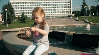 Müzik kulaklık telefona yakın çeşme ile güzel kız