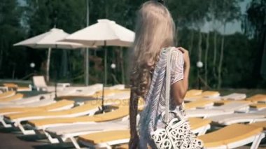 Havuz başında video klip güzel kadın şezlong genç kadına yalan rahatlatır