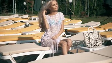 Havuz başında video klip güzel kadın şezlong genç kadına yalan rahatlatır