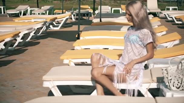 Mulher bonita deitada na cadeira de praia Mulher jovem relaxa na piscina, clipe de vídeo — Vídeo de Stock