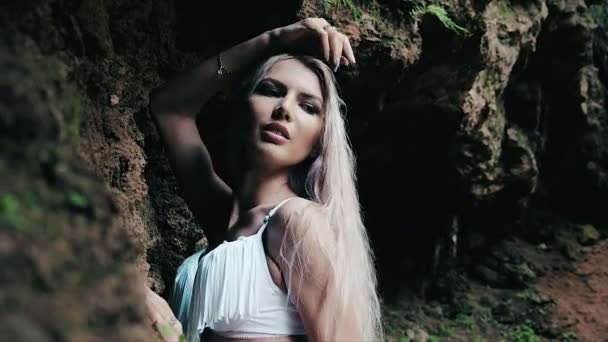 Bela mulher em um biquíni de pé perto de uma cachoeira — Vídeo de Stock