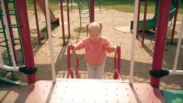Barn glidande på en bild i Park, lilla flicka som leker på lekplatsen, barn — Stockvideo
