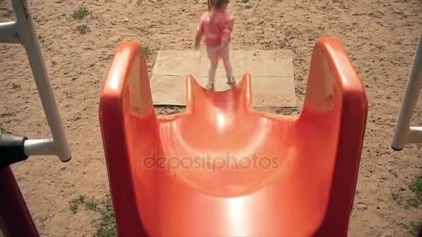 Niño deslizándose en una diapositiva en el parque, Niña jugando en el patio de recreo, Niños — Vídeos de Stock