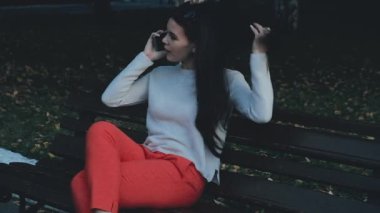 Güzel bir genç profesyonel kadın bir telefon görüşmesi, açık havada gece şehirde yaşıyor. Gülümsüyor