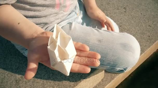 Mooi meisje lanceert papier boten in een fontein — Stockvideo