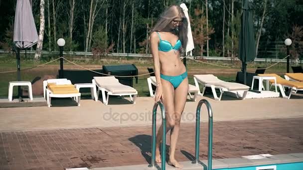 Uma mulher bonita relata uma piscina a nadar com águas pretas. — Vídeo de Stock