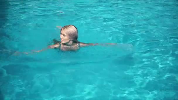 Молодая красивая женщина лежит на надувном матрасе в бассейне — стоковое видео