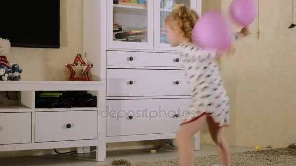 Маленька красива дівчинка танцює з повітряними кулями — стокове відео