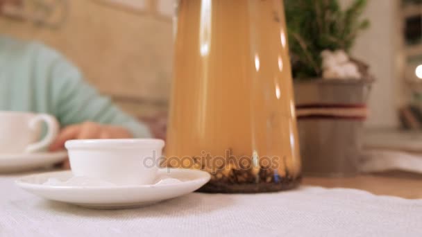 Glückliches Mädchen trinkt Tee und entspannt sich im Café, lächelt und blickt in die Kamera. — Stockvideo