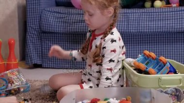 Katta oturan ve oyuncakları ile oynarken küçük kızı ile genç anne.