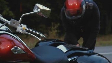 Bir adam bir motosiklet orman içinde bir yola rides