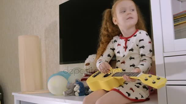 Bambino che gioca ukulele sul divano — Video Stock