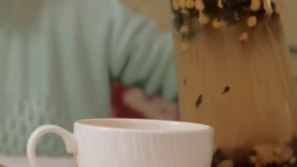 Gelukkig meisje drinken thee en ontspannen in het café, glimlachen en kijken naar camera. — Stockvideo