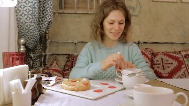 Счастливая женщина ест сладкий вкусный десерт — стоковое видео