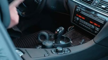 Rap pahalı bir beyaz araba arka plan üzerinde siyah ceket genç bir adam okur