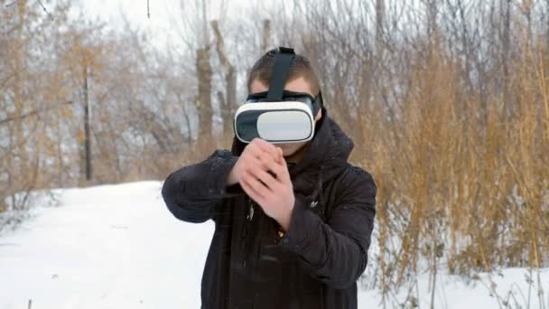 Young woman getting experience in using VR-headset outdoor at winter park — Stock Video