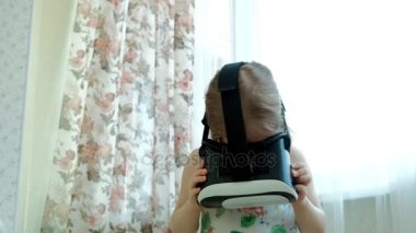 VR kulaklık giyen küçük kız beyaz gömlek izlerken 360 video evde,.