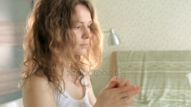 Jovem mulher vestindo rímel e olhando no espelho da mão no quarto em casa — Vídeo de Stock