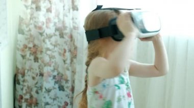 VR kulaklık giyen küçük kız beyaz gömlek izlerken 360 video evde,.